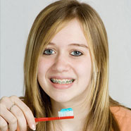 stock photo of a girl with braces brushing her teeth